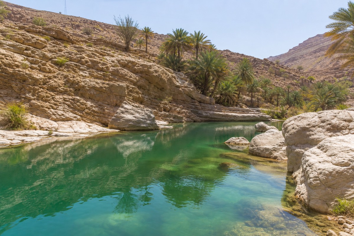 Emerald-green pools between rock walls at Wadi Bani Khalid oasis in Oman