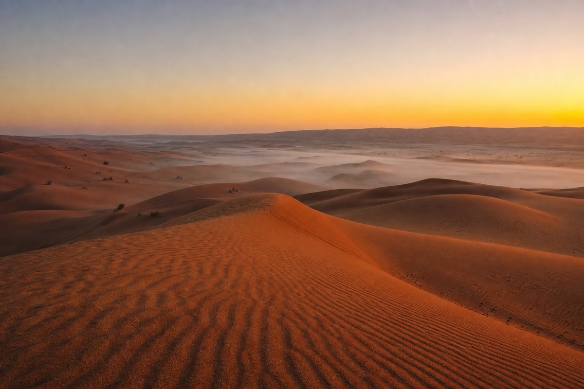 First light breaking over the crest of a Wahiba Sands dune at sunrise